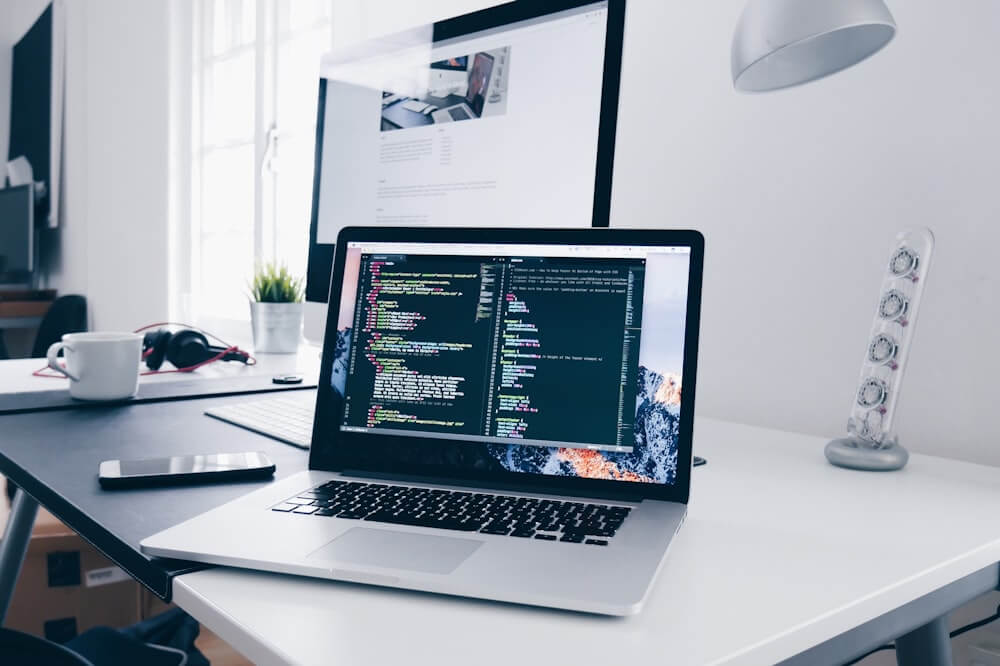 Developer workspace with laptop showing code and design tools